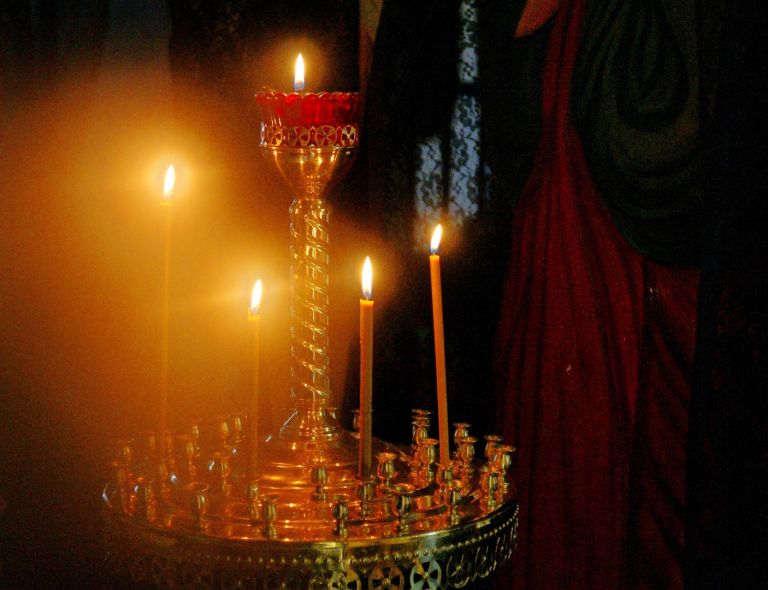 Zdjęcie przedstawiające lichtarz z zapalonymi świecami
