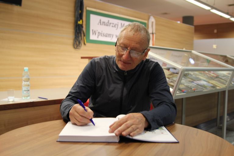 Andrzej Marcisz podpisuje egzemplarz książki
