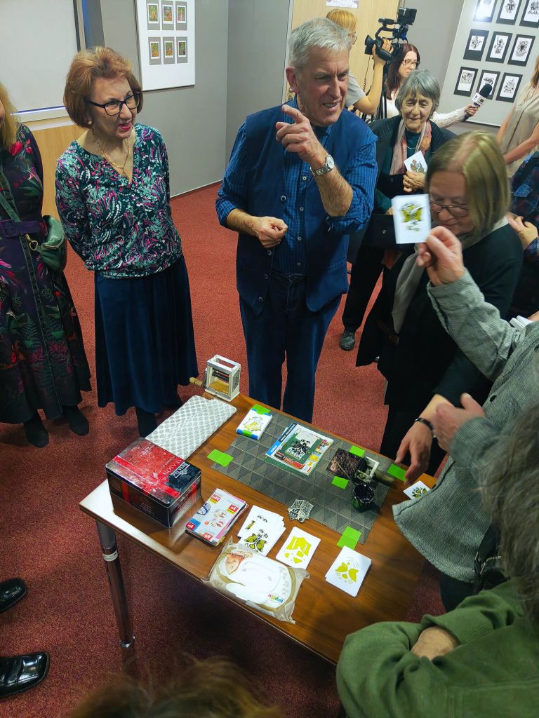 Grupa uczestników słucha autora jak stworzona jest grafika.