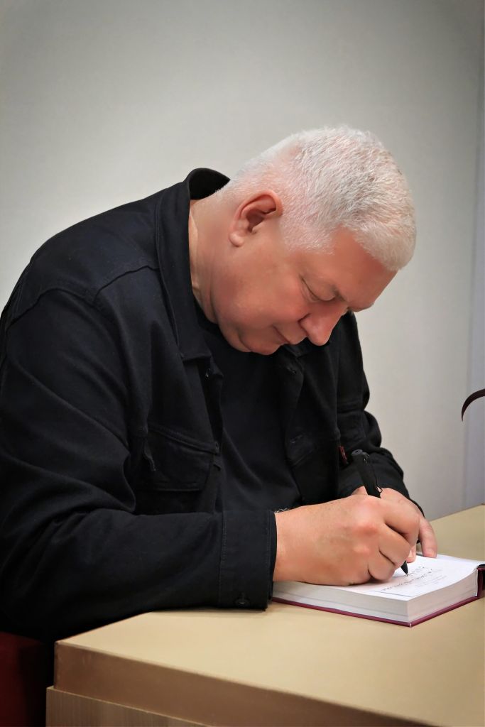 Autor książki rozdaje autografy